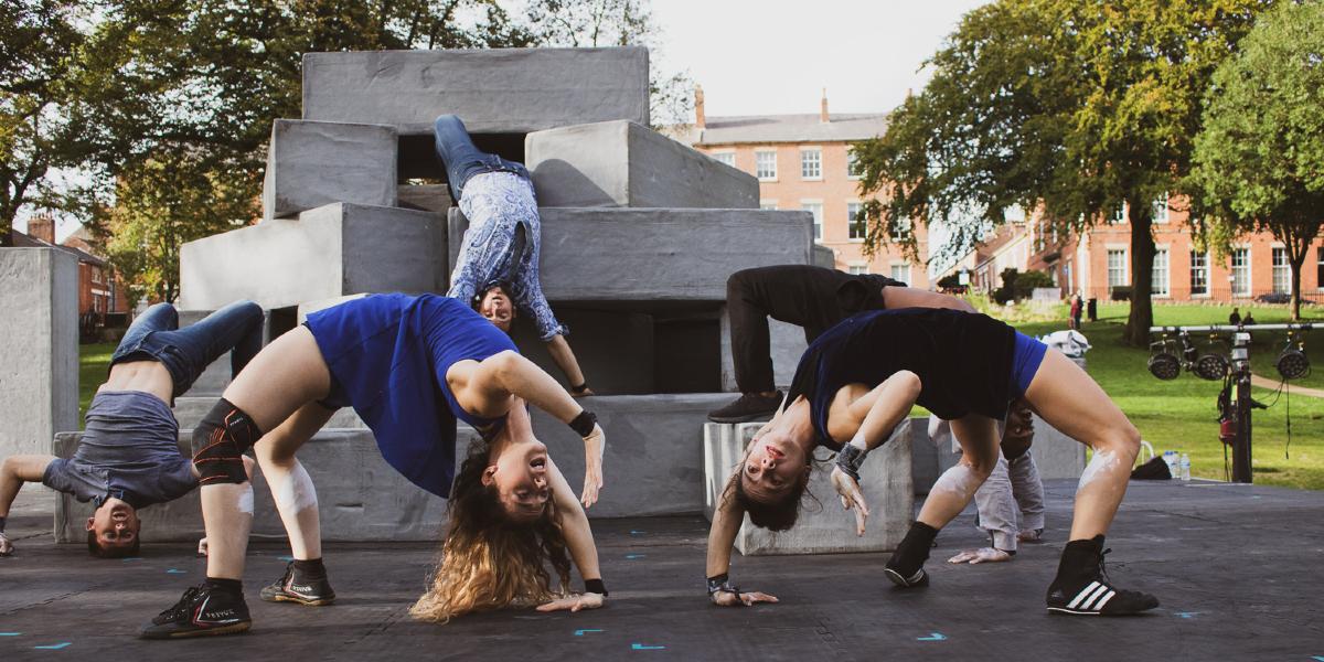 The artist block doing a gymnastic move whilst upside down.