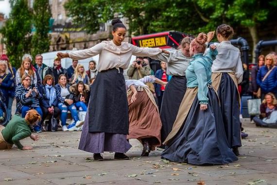 Dance performance with women dressed in old cotton worker dresses on Preston Flag Market.