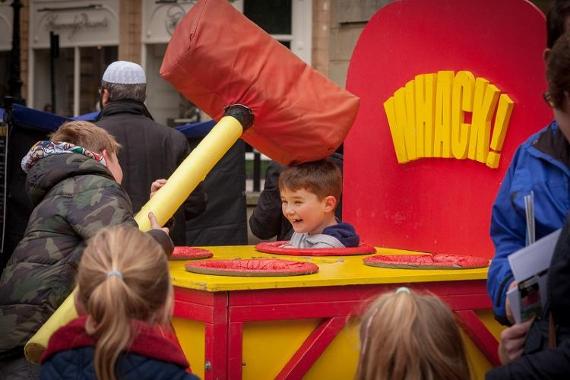 Two boys playing in giant whac-a-mole game.
