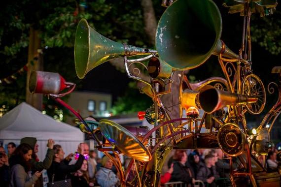 Parade installment made from old horns and machine parts, lit up on Preston's streets at night.